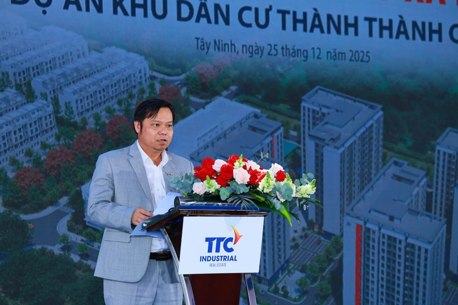 A person standing at a podium with flowersAI-generated content may be incorrect.